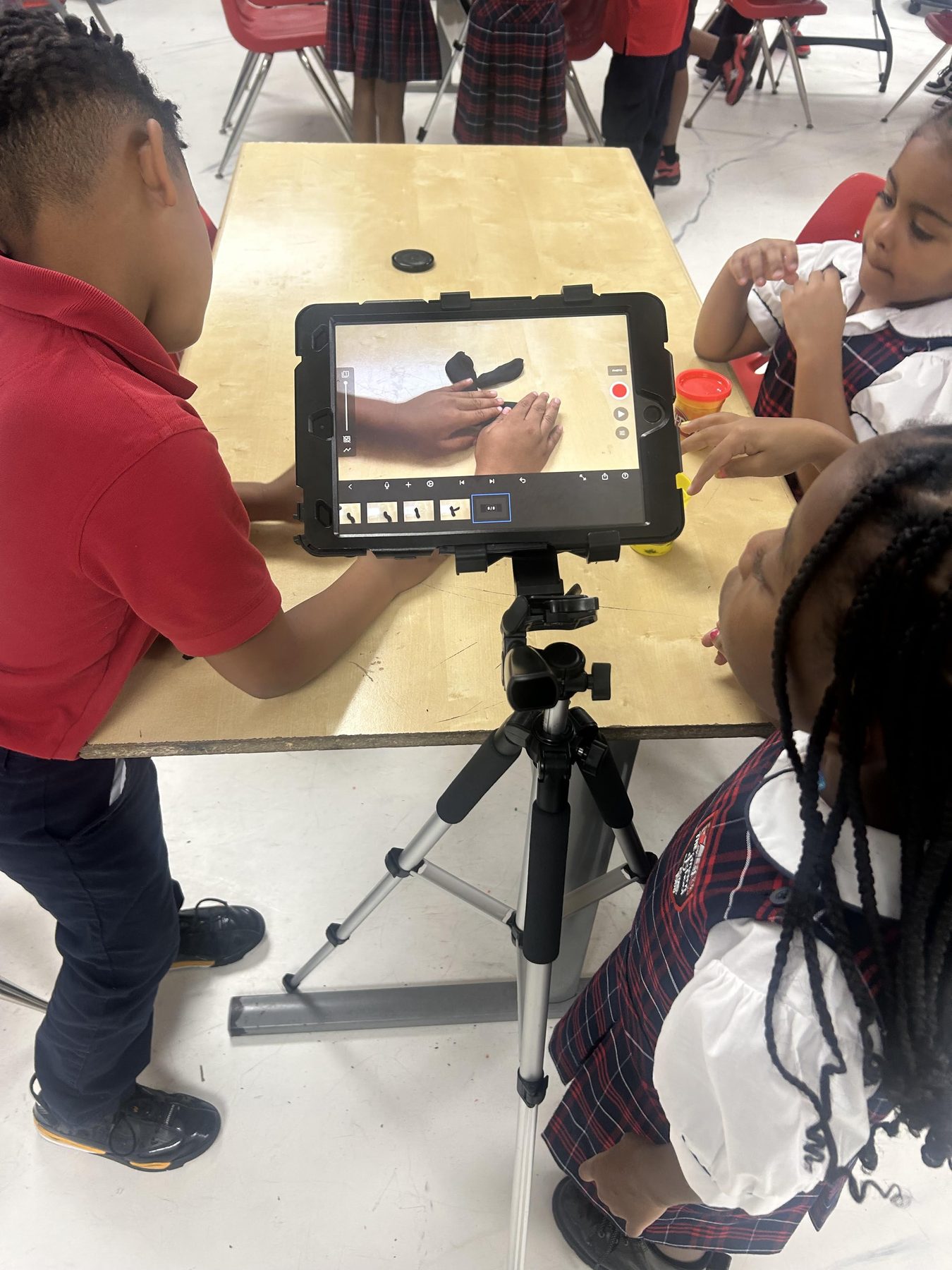 Young Imani students recording a stop-motion animation project.