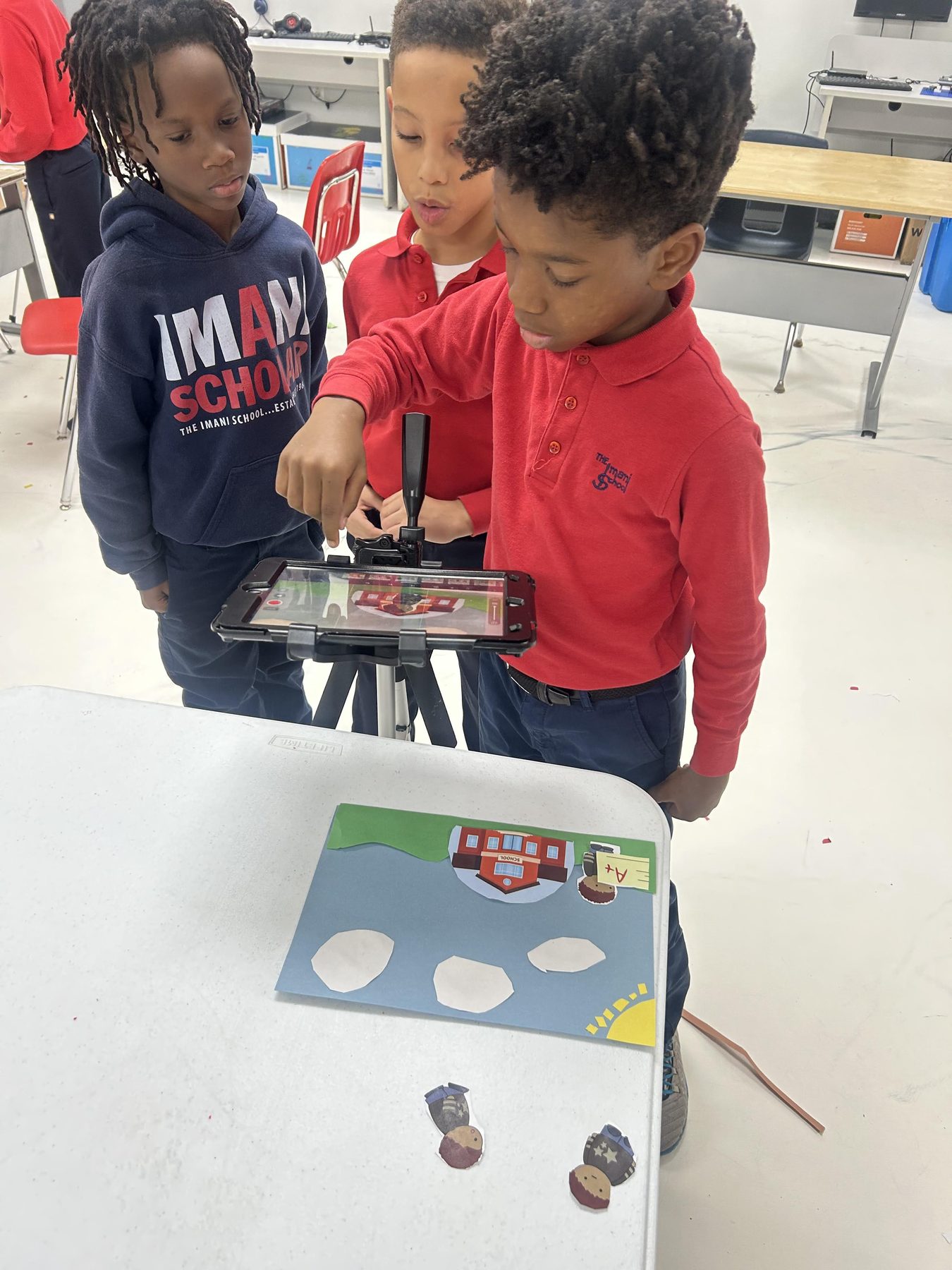 Imani students using a tablet mounted on a tripod to create a stop-motion animation.