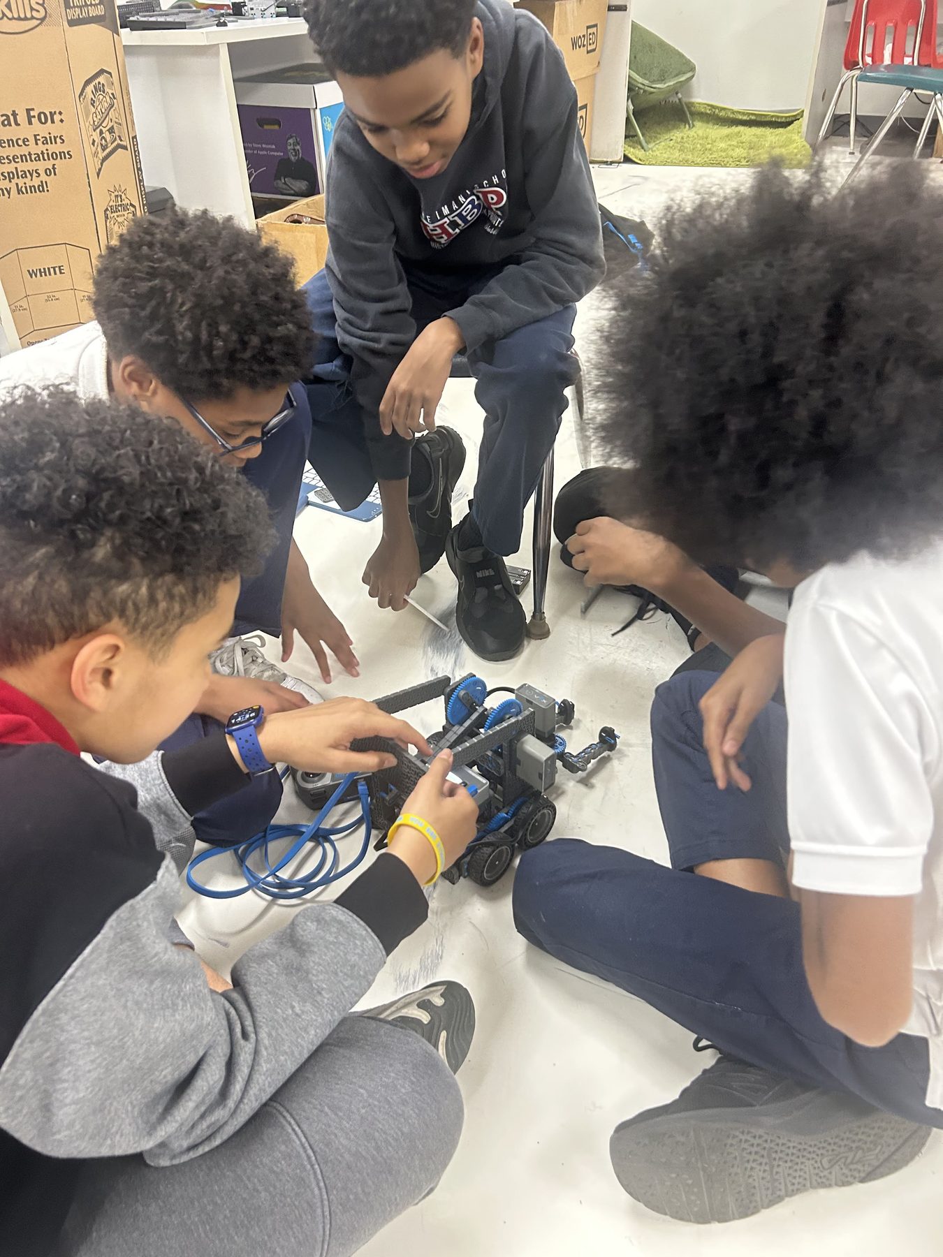 Group of Imani students collaborating on a robotics build.