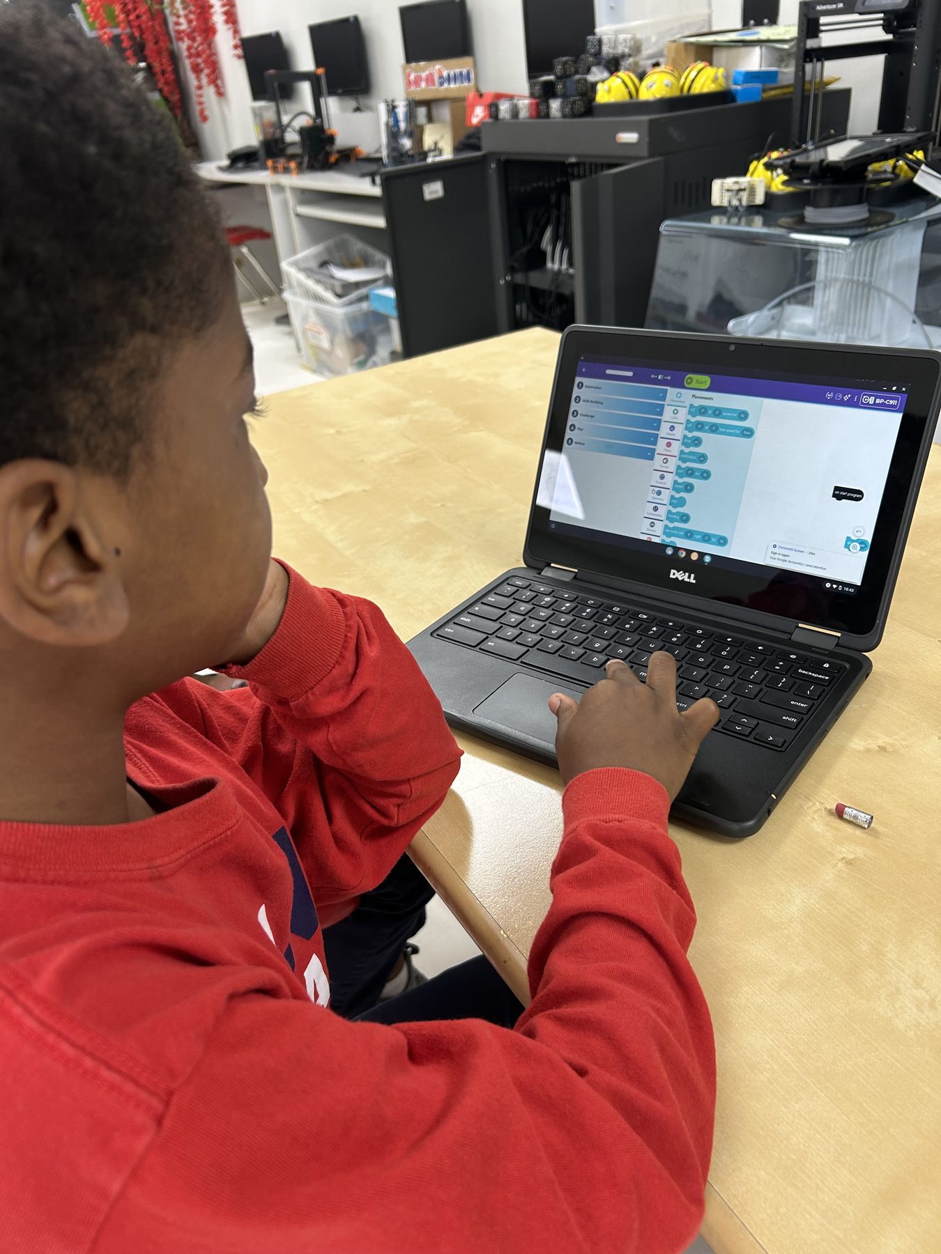 Imani student writing a block-based program on a laptop in the STEM lab.