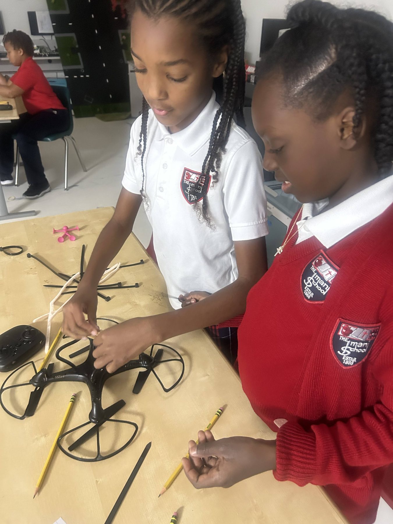 Two Imani students working together to assemble a classroom drone.